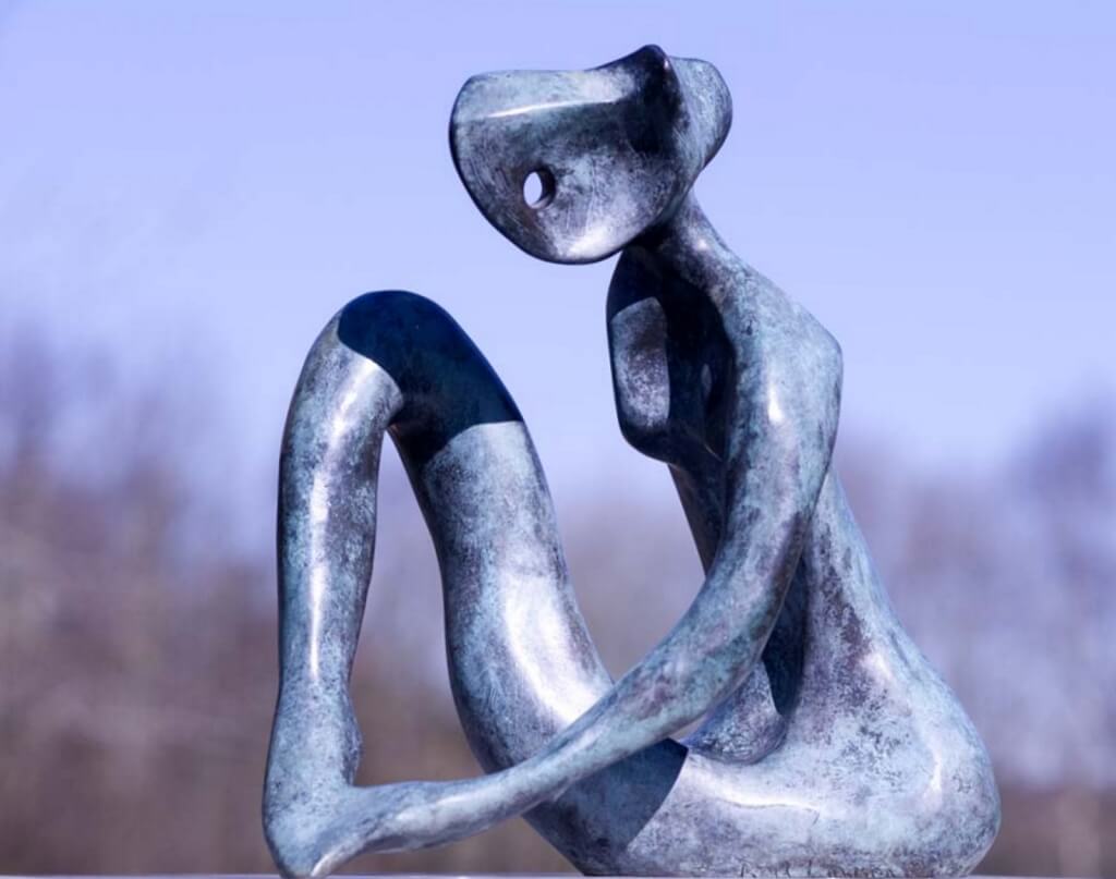 Contemplation - an abstract sculpture of a figure in bronze. The figure's left arm appears to be holding its left foot. The finish is a mottled verdigris colour.
