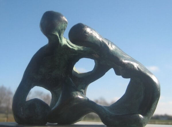 A Day in the Park - a semi-abstract bronze sculpture of two figures, one male, one female, sitting close together. The female is bending over.