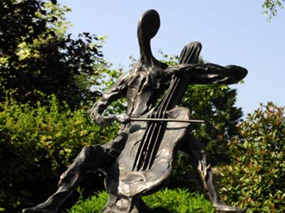 A Day in the Park - a semi-abstract bronze sculpture of two figures, one male, one female, sitting close together. The female is bending over.