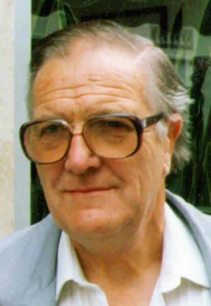 Portrait image of Eric Gibbard - CEO of Burghleighfield Foundry wearing glasses, a white shirt and pale blue-grey jacket.