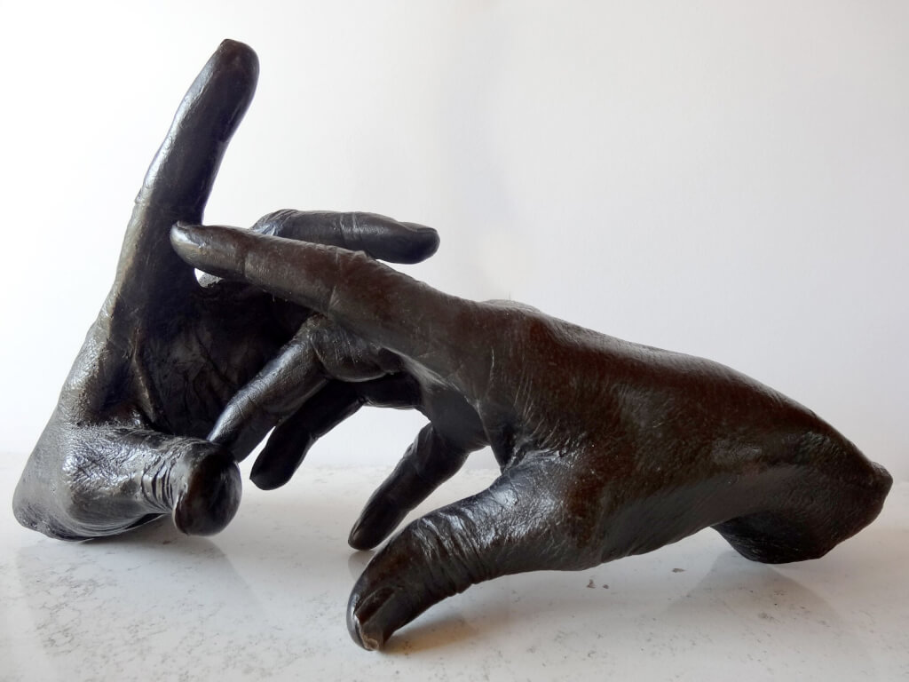 The Sculptor's Hand at work - bronze sculpture of a right hand holding a dentist's drill on a cable