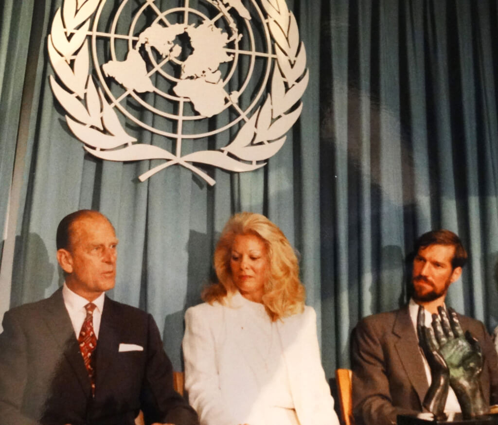 HRH Prince Philip Duke of Edinburgh (left) at the UN in New York to present bronze sculpture Hands in Prayer. UN logo above.