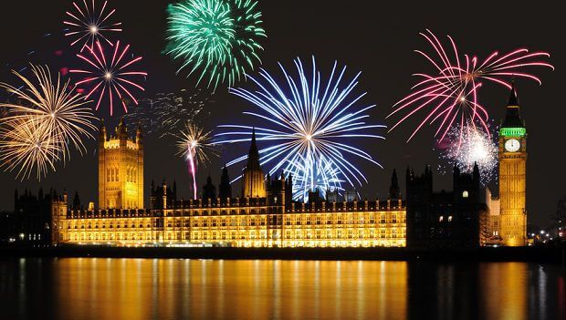 London's Houses of Parliament & Big Ben at midnight seen across the river with fireworks